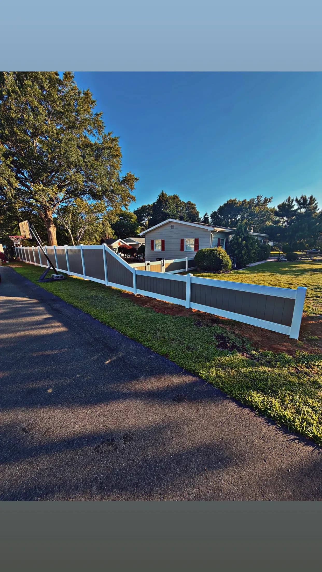 Project Two-Tone Vinyl Fence with a Stepped Slope and Clean Gate Finish image